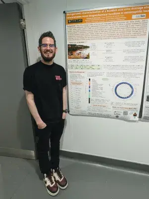 Michael McDonald standing in front of his research poster